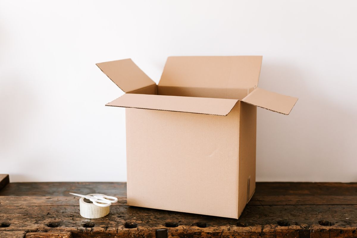An open cardboard box on a wooden desk