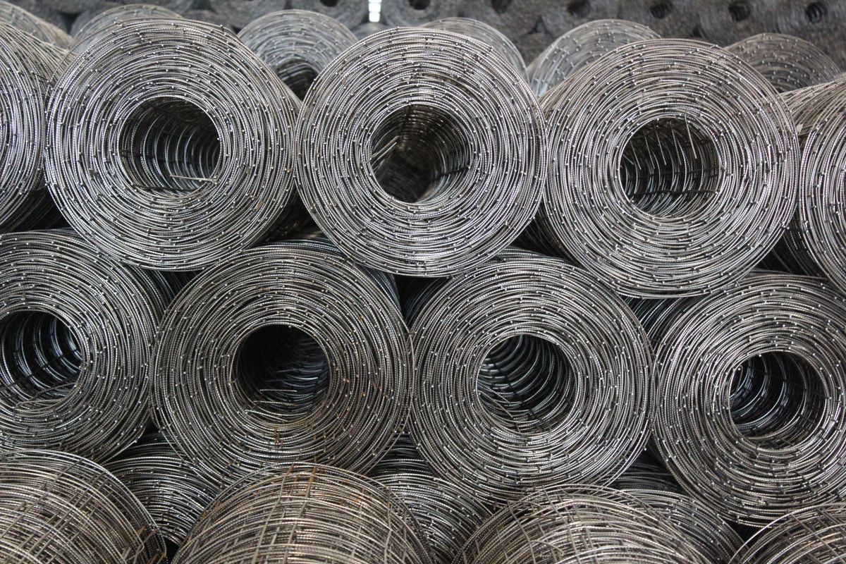 Rolls of galvanised wire mesh stacked in a store